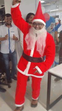 a man dressed as santa claus stands next to another man in a white shirt