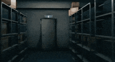 a man in a suit is walking through a dark hallway with shelves full of books