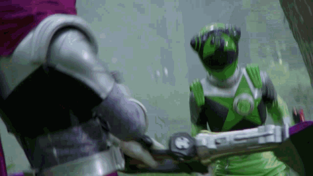 a green power ranger is standing next to a purple ranger