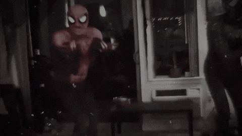 a black and white photo of a person in a spider man costume .