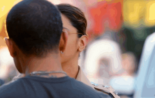 a woman in a police uniform kisses a man 's neck