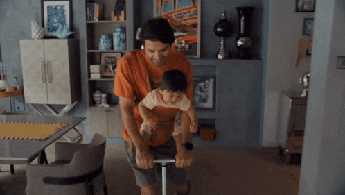 a man is carrying a child on his shoulders while riding a scooter