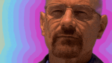 a man with glasses and a beard has a pink background