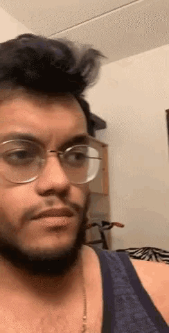 a man with glasses and a beard is looking at the camera