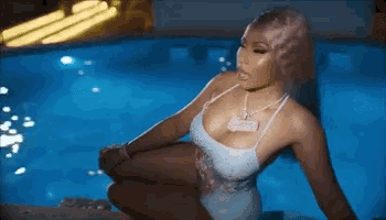 a woman in a bathing suit is sitting in a pool .