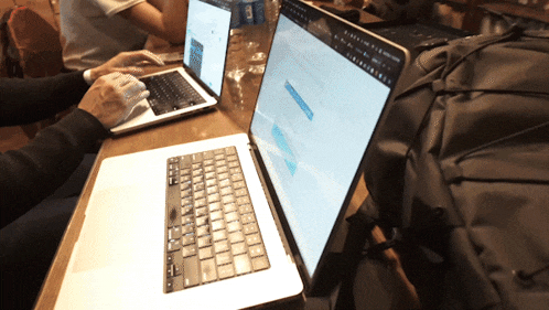 a person is typing on a laptop that has a search bar on it