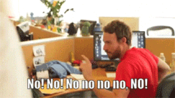a man in a red shirt is sitting at a desk and says " no "