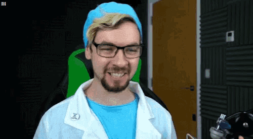 a man with glasses and a beard is wearing a lab coat and a blue hat