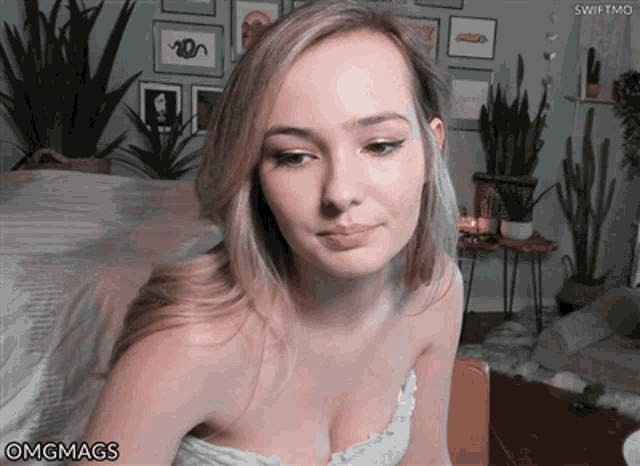 a woman in a white top is looking at the camera with omgmags written below her