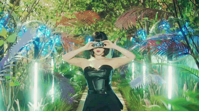 a woman in a black dress is taking a picture of herself in a forest
