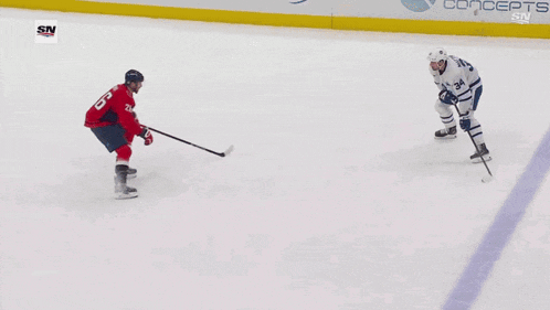 a hockey game is being played in front of a geico banner