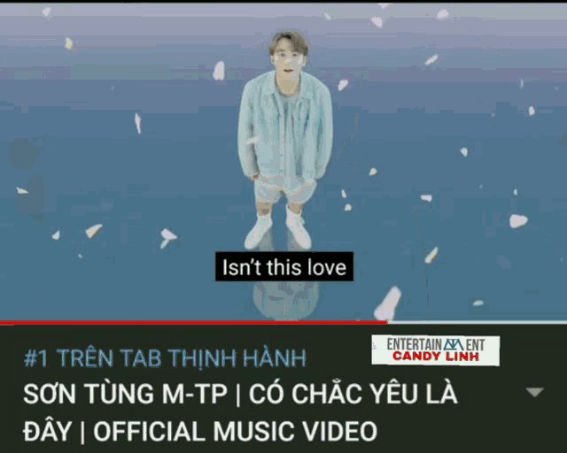 a man in a blue jacket and shorts is standing in front of a blue background that says " isn 't this love "