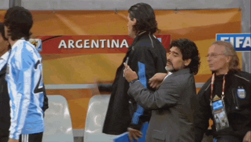a man in a suit is standing in front of a sign that says argentina