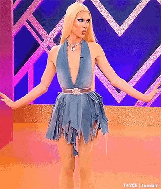 a drag queen is wearing a blue dress with a plunging neckline and a belt .
