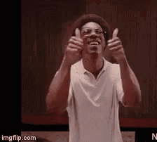 a man in a white shirt is giving two thumbs up .