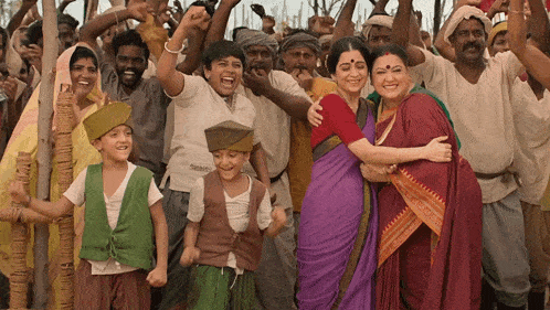 a group of people are posing for a picture and one of them is wearing a purple saree