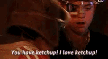 a boy wearing a helmet and goggles says you have ketchup ! i love ketchup !