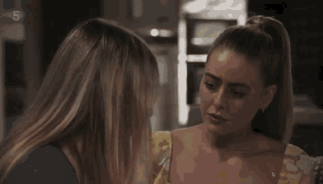 two women are talking to each other and the number 5 is on the bottom right