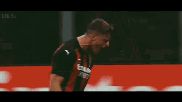 a soccer player is celebrating a goal in front of a fly emirates banner .