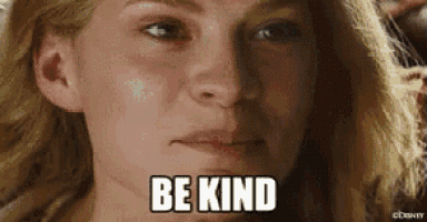 a close up of a woman 's face with the words `` be kind '' on her face .