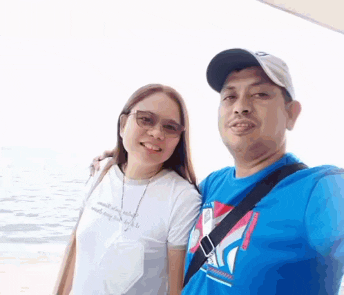 a man and a woman are standing next to each other on a beach .