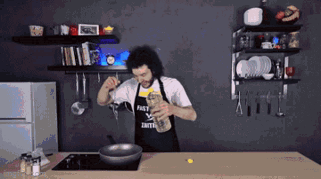 a man wearing an apron that says " fast " is pouring something into a pan