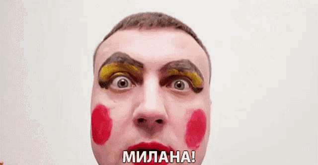 a man with makeup on his face is making a funny face and saying `` milana '' .
