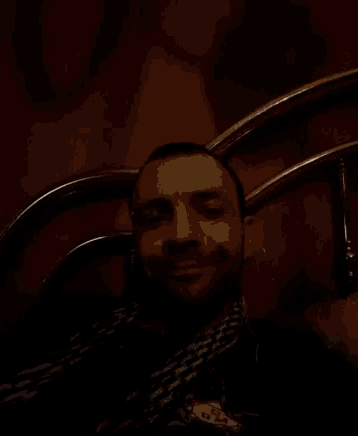 a man with a beard is laying on a bed and looking at the camera
