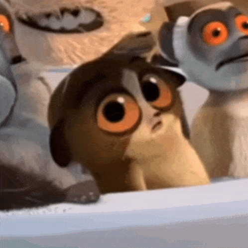 a group of cartoon animals with big orange eyes are standing next to each other on a table .