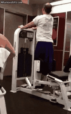 a man is doing a pull up in a gym .