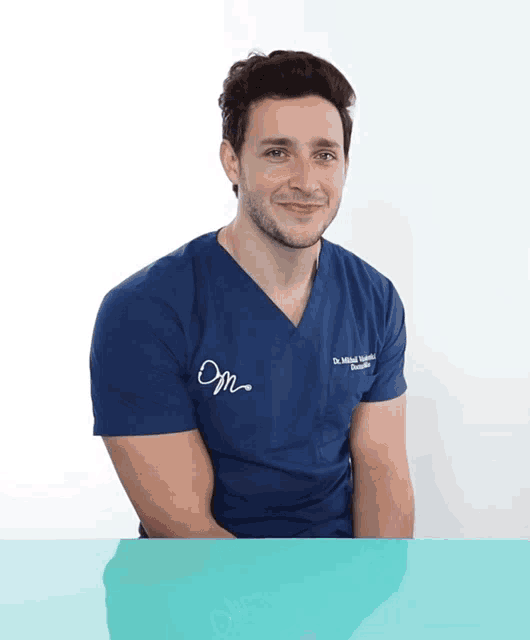 a man wearing a blue scrub top that says dr. khalid khalid on it