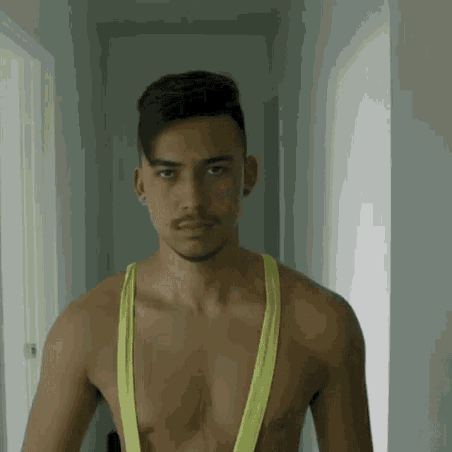 a shirtless man is wearing a neon yellow tank top