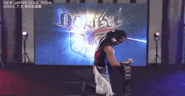 a wrestler is kneeling in front of a screen that says new japan soul 2024