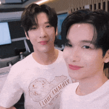two young men are posing for a picture with one wearing a t-shirt that says i love emmaly