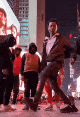 a group of young men are dancing on a city street .