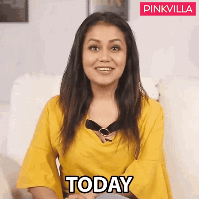 a woman in a yellow shirt is sitting on a couch and says today