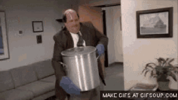 a man in a suit and tie is holding a pot in his hands .