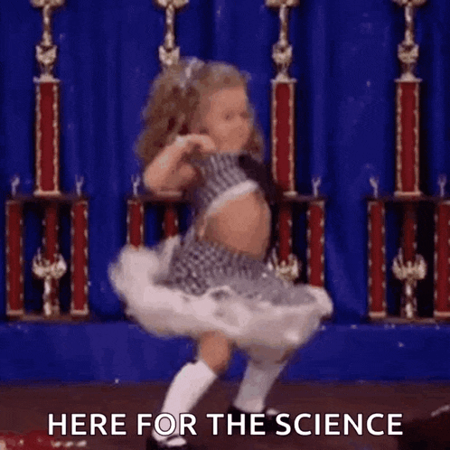 a little girl is dancing on a stage in front of trophies and the words here for the science .