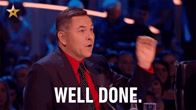 a man in a suit and tie says " well done "