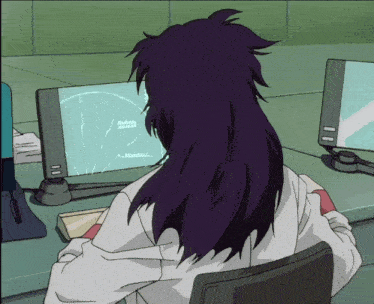 a person with purple hair is sitting in front of a computer monitor with a circle on it that says ' a '