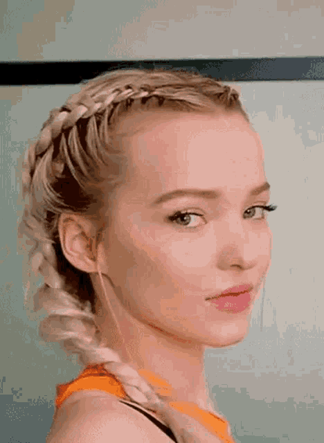 a close up of a woman 's face with a braided hairstyle .