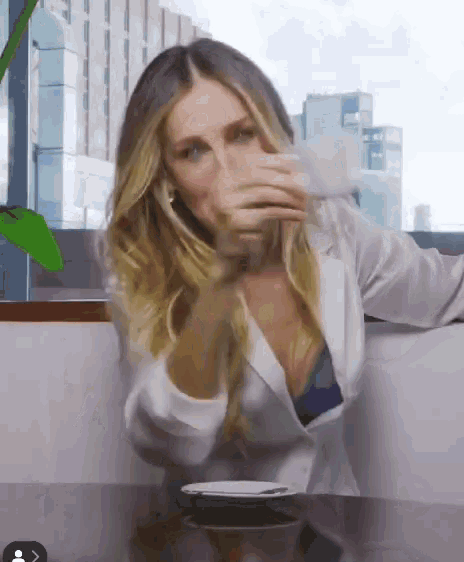 a woman sitting at a table with a cup of coffee in her hand