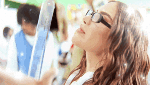 a woman wearing glasses is taking a selfie with her phone