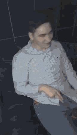 a man in a blue shirt is sitting on a black couch