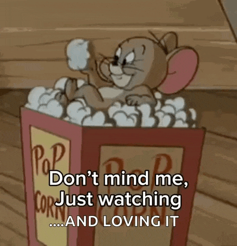 a cartoon mouse is sitting in a box of popcorn and says `` don t mind me , just watching and loving it ''