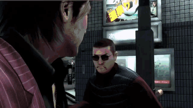 a man wearing sunglasses talks to another man in front of a sign that says ' a ' on it