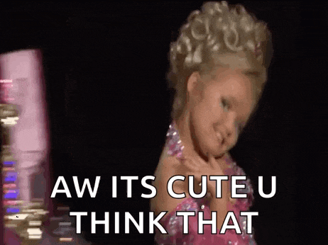 a little girl is wearing a pink dress and dancing on a stage .