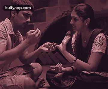 a man and a woman are sitting on the floor talking to each other