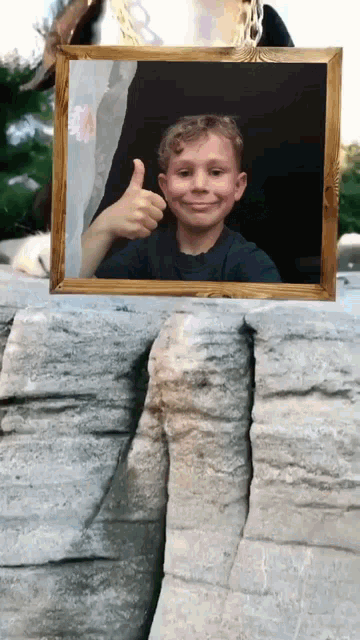 a picture of a boy giving a thumbs up