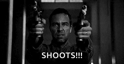 a man is holding two guns in his hands in a black and white photo and says `` shoots '' .